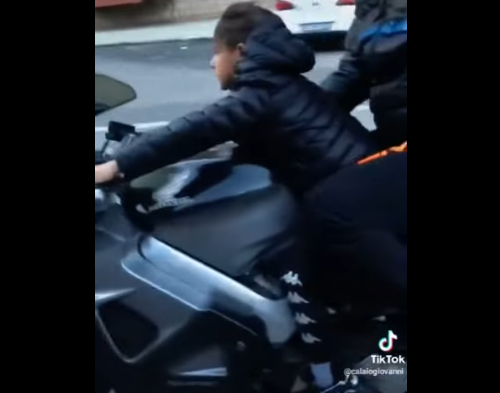Bambino di 8 anni alla guida di una moto di grossa cilindrata nel cuore della città Bambino di 8 anni alla guida di una moto di grossa cilindrata nel cuore della città